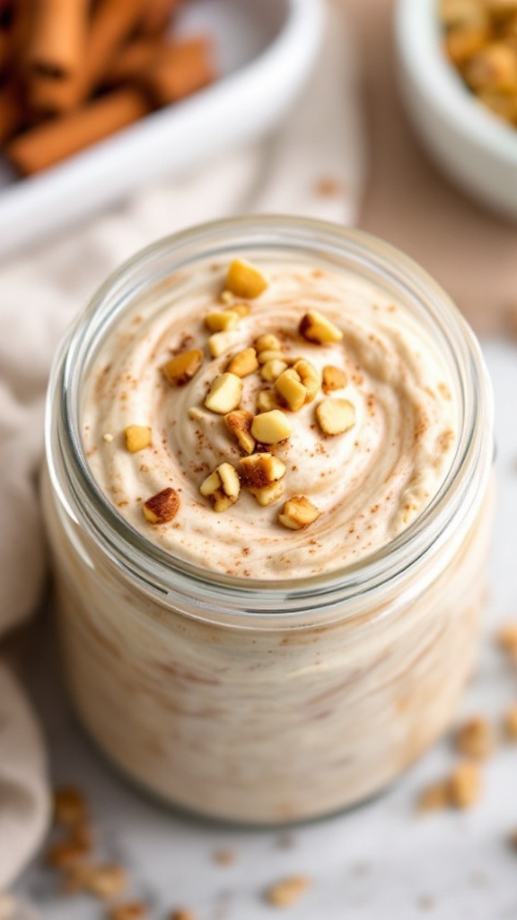 A jar of cinnamon roll overnight oats topped with nuts and a sprinkle of cinnamon.