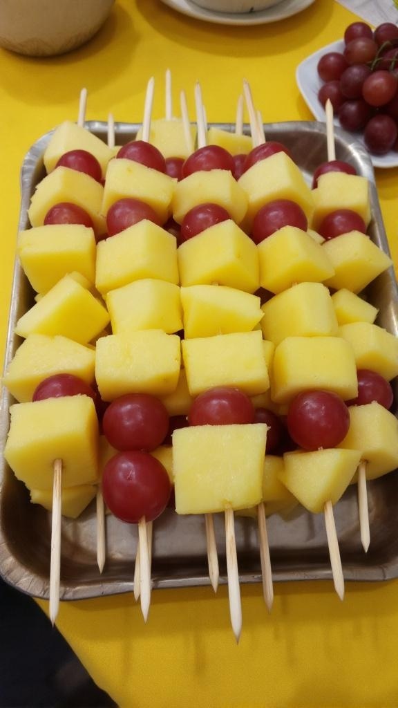 Colorful pineapple and cherry tomato skewers on a platter